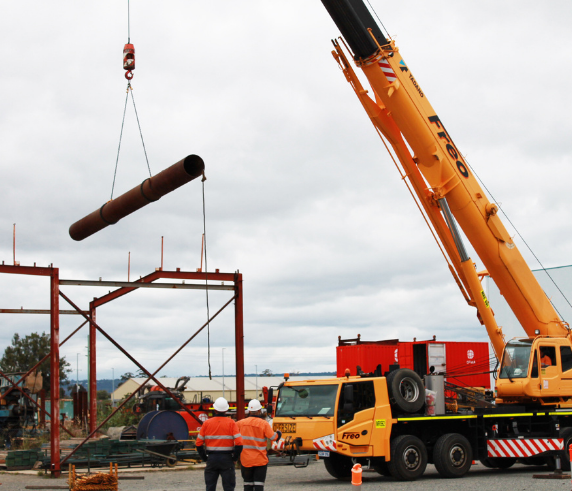 OPERATE A SLEWING MOBILE CRANE (UP TO 60 TONNES). A mobile crane lifting a large cylindrical object at a construction site