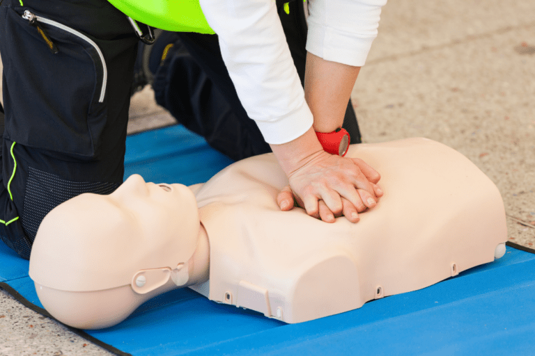 Provide CPR. Trainee performing CPR on a mannequin during a CPR certification course