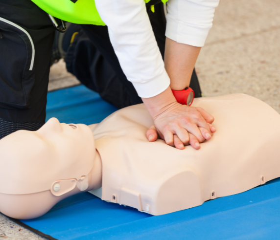 Provide CPR. Trainee performing CPR on a mannequin during a CPR certification course.