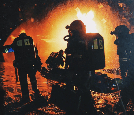Incident Commander Training. Firefighters in action during an intense fire suppression training exercise at night