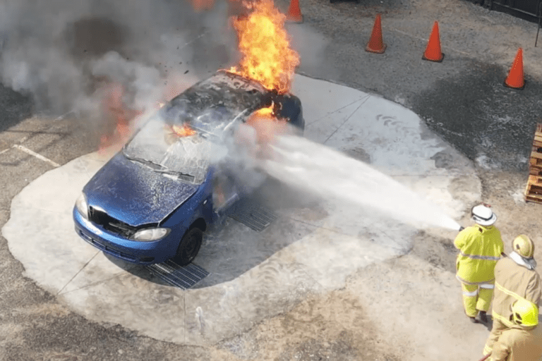 Mines Rescue Training - Safety Drills. Firefighting training in progress at Saferight facility, with trainees extinguishing a car fire.