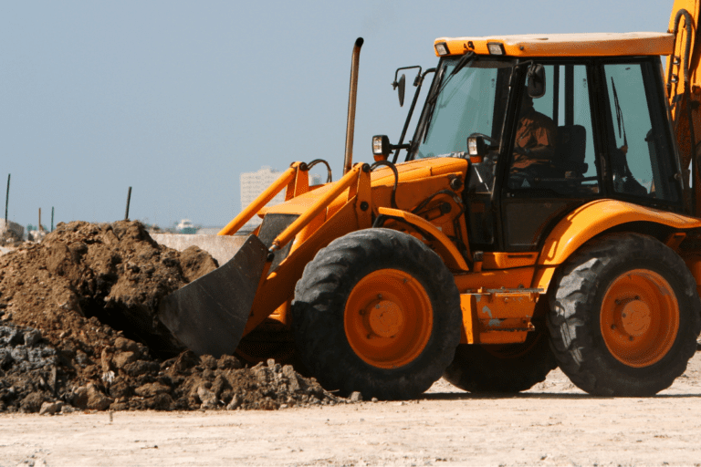 Orange wheeled front-end loader with a large bucket, ready for operation on a civil construction site