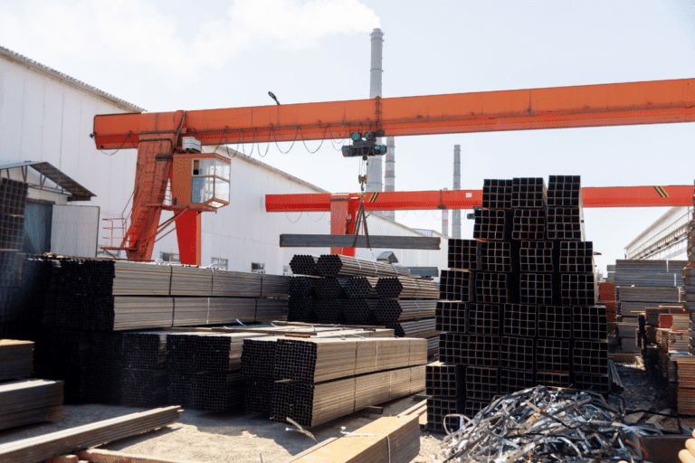 Operate a Bridge and Gantry Crane. A bridge crane moving steel beams at an industrial facility during a crane operation course