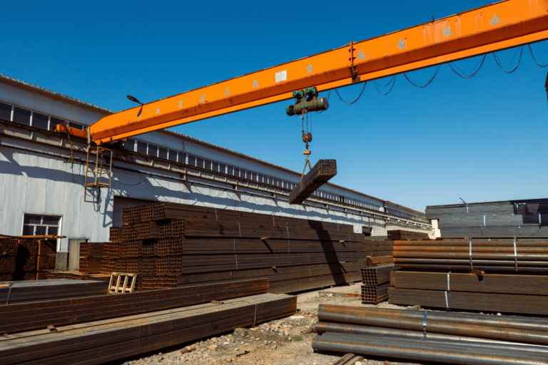 Gantry Crane Ticket Perth - Participant Operating Gantry Crane. Overhead Crane Training Perth - Overhead Crane in Operation. A bridge crane moving steel beams at an industrial facility during a crane operation course.