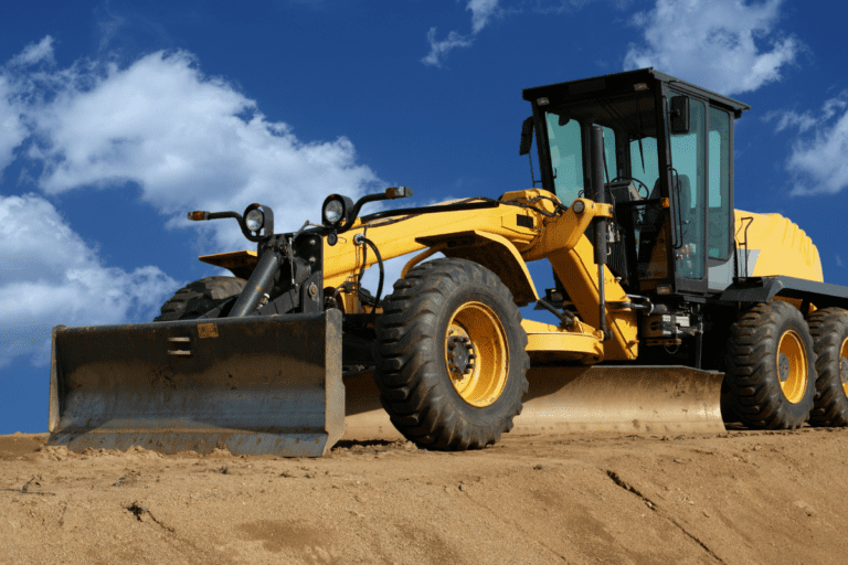 A grader on a construction site with a blue sky background doing the Conduct Civil Construction Grader Operations / Grader Ticket Perth / Grader Operator Training Course