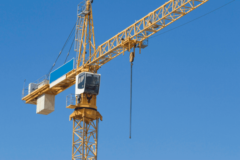 Large tower crane being operated with a blue sky in the background.