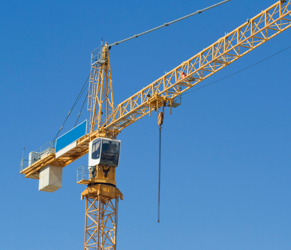 Large tower crane being operated with a blue sky in the background.