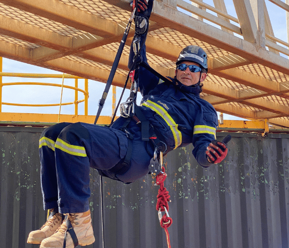 A trainer harnessed and suspended from a structure outdoor participating in Saferight's Working Safely From Heights course delivered at Saferights training facility.