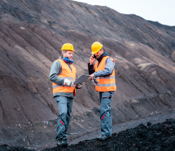 Site Senior Executive WHS Risk Management. Two safety professionals conducting a field assessment in a mining environment.