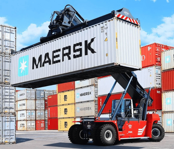 A reach stacker lifting a MAERSK cargo container at a container terminal