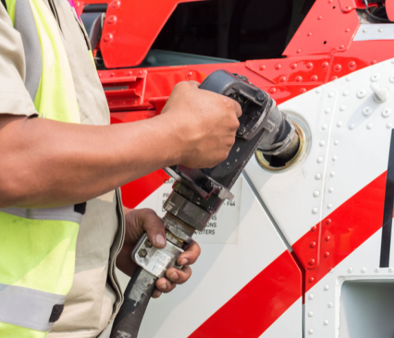 helicopter refuelling. A person wearing hi-vis refuelling a helicopter.